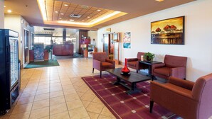A hotel lobby with a seating area, a refrigerator, and a painting on the wall. - Holiday Inn Hinton by IHG (Hinton)