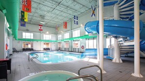 An indoor swimming pool with a hot tub, lounge area, and a water slide. - Holiday Inn Hinton by IHG (Hinton)