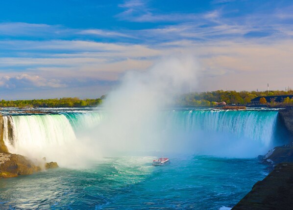 A large waterfall with a boat in the water.