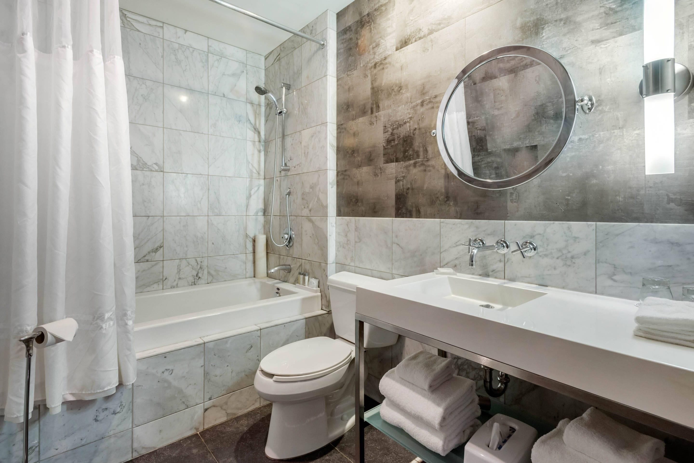 A modern bathroom with a bathtub, toilet, and sink.