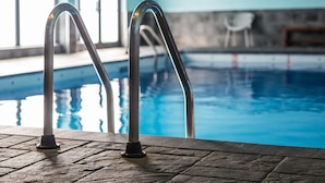 A swimming pool with metal railings and a stone-tiled deck. - Hotel Quartier, an Ascend Collection Hotel (Québec City)