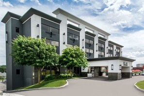 Moderni hotellirakennus, jossa on tasakatto, suuret ikkunat ja hyvin hoidettu nurmikko.