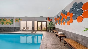 Una piscina techada, sillones reclinables de piscina