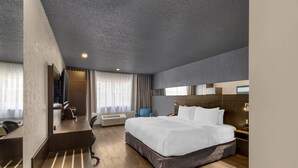 A modern hotel room with a large bed, a desk, a chair, and a TV. - Hotel Quartier, an Ascend Collection Hotel (Québec City)