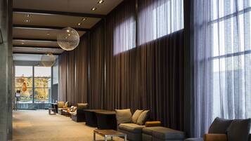 A spacious living area with a large window, a sofa set, and a coffee table.