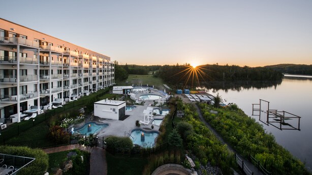 Ein Hotel mit mehreren Etagen, Außenpools und Seeblick.