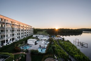 A hotel with multiple floors, outdoor pools, and a lake view.