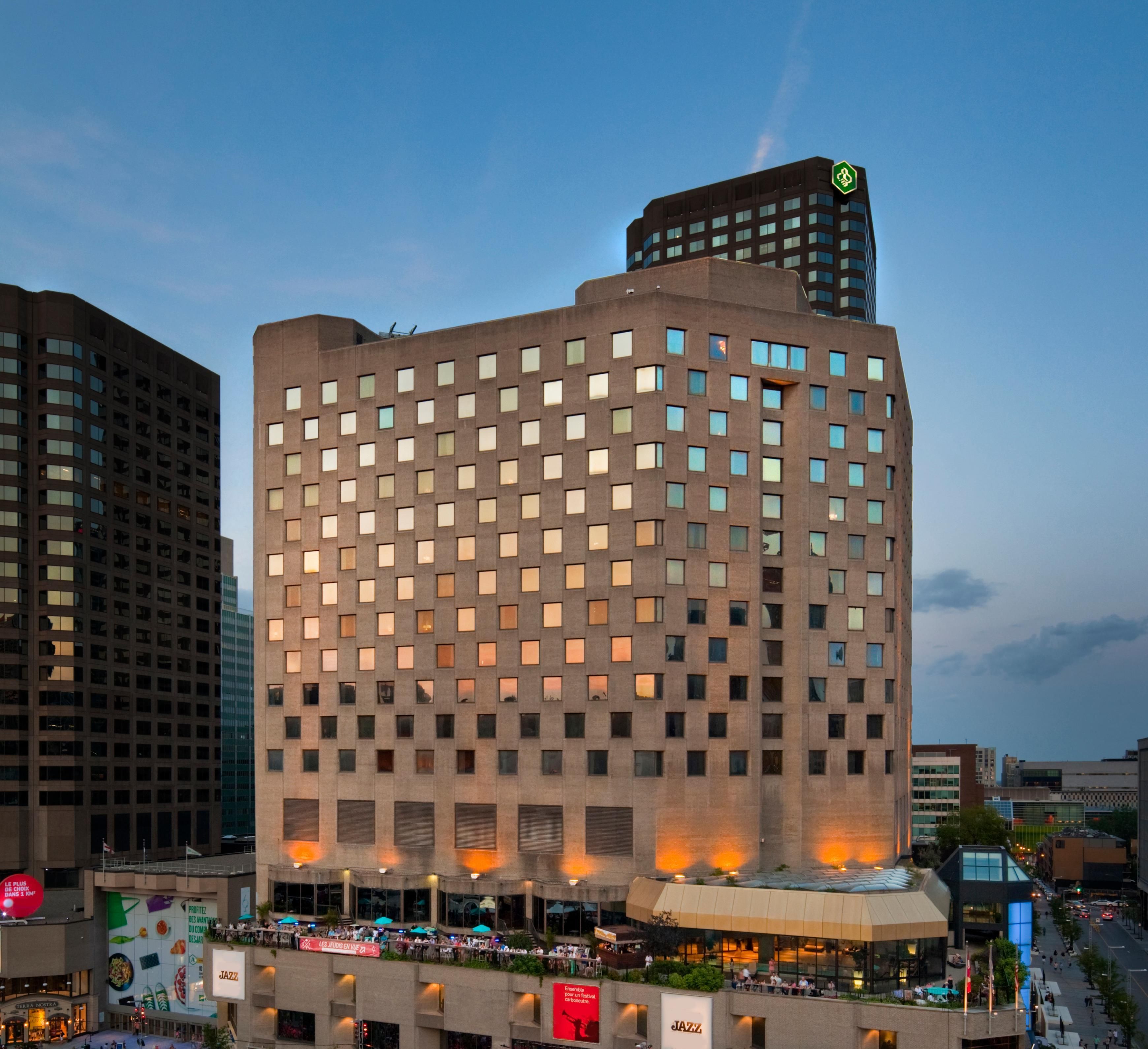 A multi-story hotel with a grid of windows and a flat roof terrace.