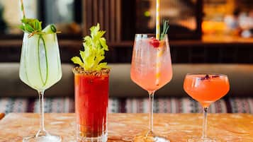 Four cocktails on a marble table with a blurred background.