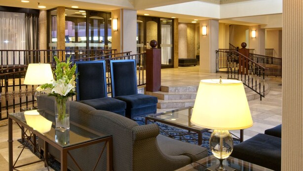 A spacious lobby with high ceilings, a grand staircase, and comfortable seating areas. - Delta Hotels by Marriott Bessborough (Saskatoon)