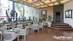 A hotel lobby with wicker chairs, a reception desk, and a large mirror. - Hotel Royal Reforma (Mexico City)