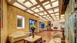 A spacious lobby with a high ceiling, a reception desk, seating area, and a large window. - Hotel Royal Reforma (Mexico City)