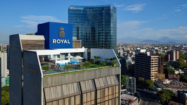 A hotel with a prominent 'ROYAL' sign, modern architecture, and a view of the cityscape. - Hotel Royal Reforma (Mexico City)