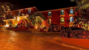 A large, multi-story building with arched windows and a courtyard. - Hotel Irma (Zihuatanejo)