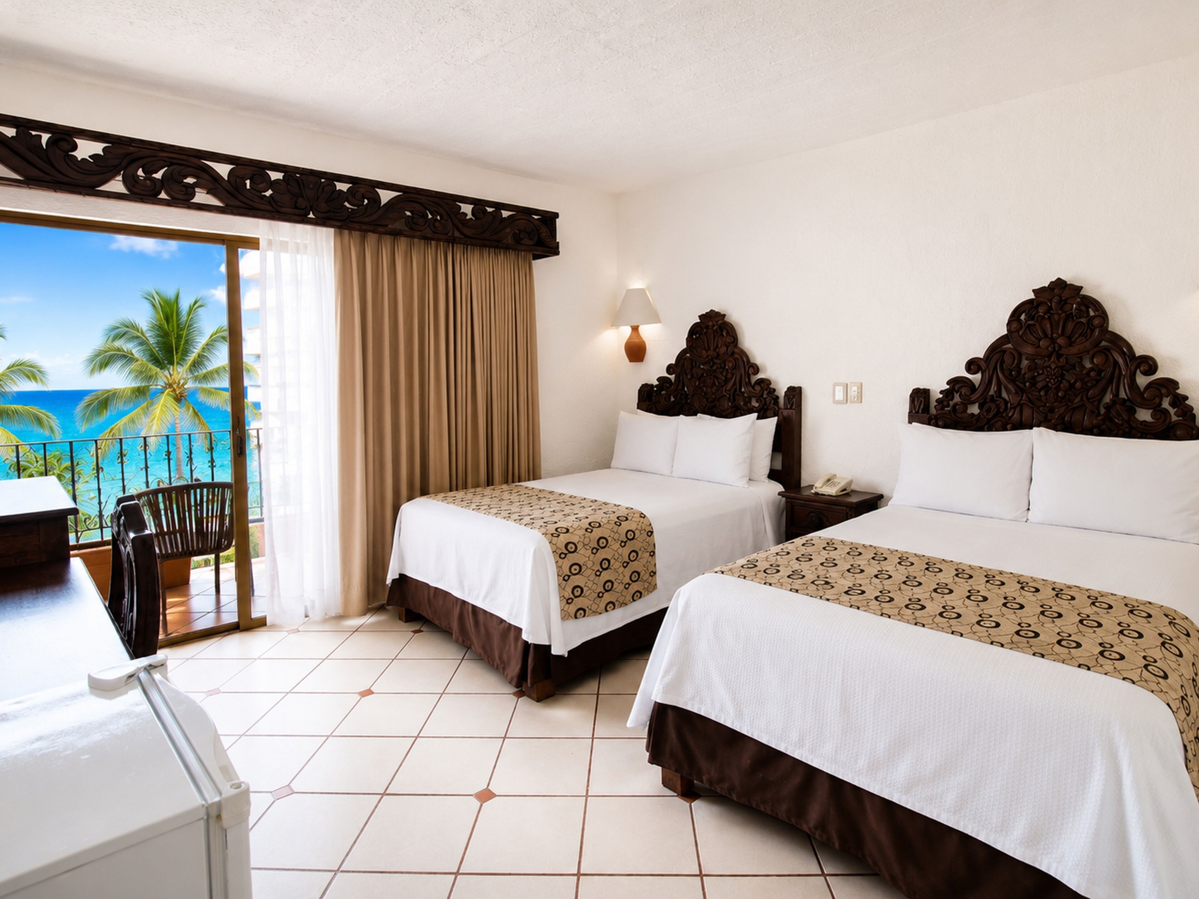 A hotel room with two beds, a balcony with a view of palm trees and the ocean, and a desk with a chair.