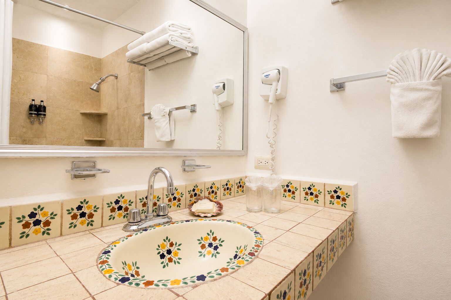 A bathroom with a sink, mirror, towel rack, and a hairdryer.