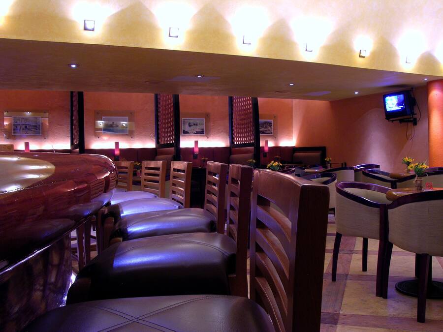 A restaurant interior with booths, a bar area, and a television screen.