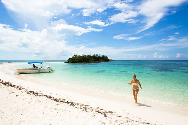 Een privéstrand, wit zand, parasols, strandlakens