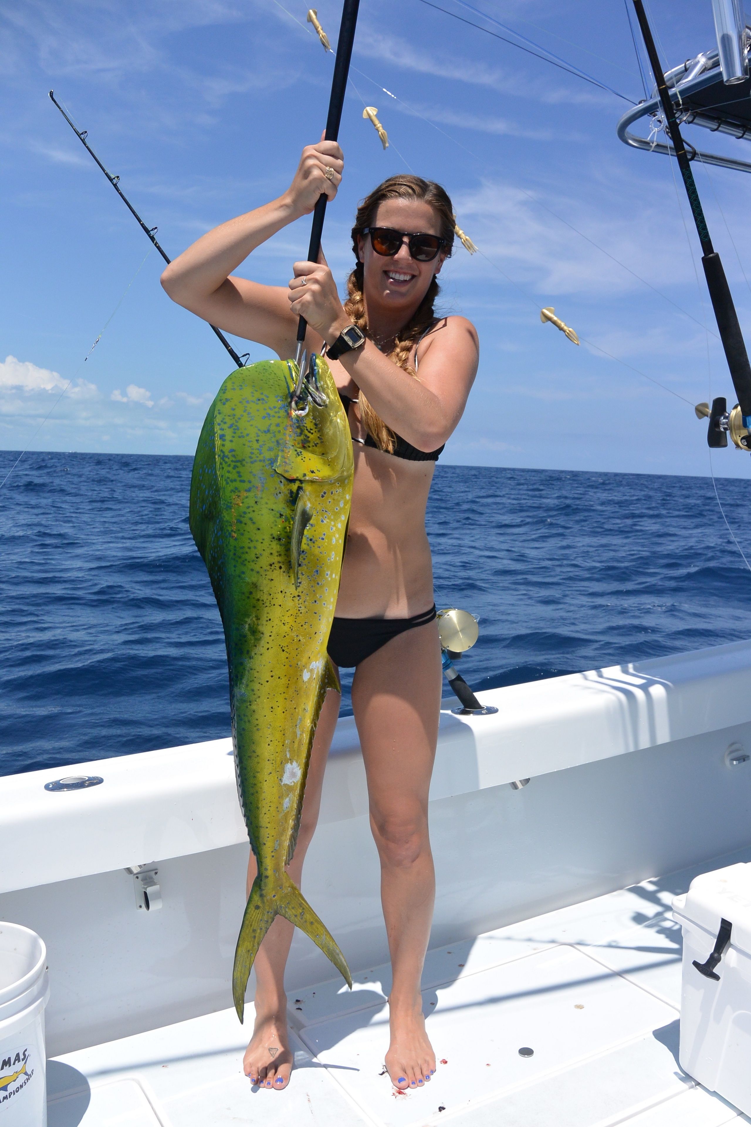 A person holding a large fish on a boat.
