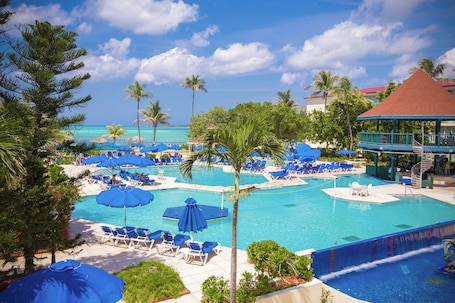 Una piscina al aire libre, sillones reclinables de piscina