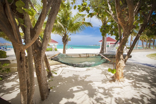 On the beach, white sand, beach cabanas, sun loungers
