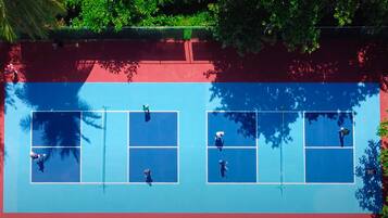 Ilmakuva tenniskentästä, jossa on neljä osaa, ja jonka ympärillä on puita.