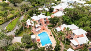A residential area with multiple houses, a swimming pool, and a road. - Fourways Inn (Southampton Parish)