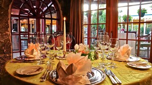A table set for a meal with a candle, wine glasses, and a floral centerpiece. - Fourways Inn (Southampton Parish)