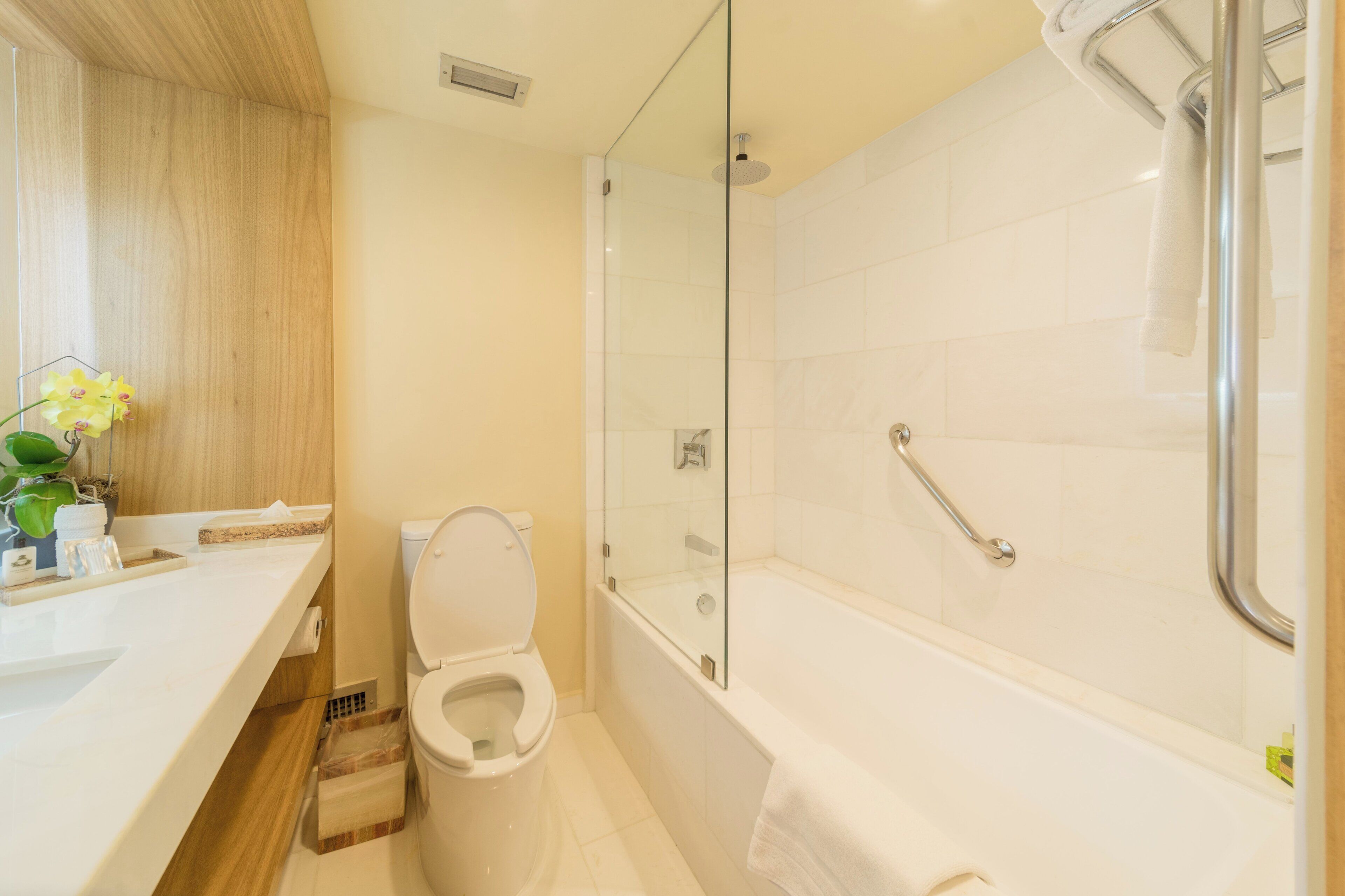 A modern bathroom with a toilet, sink, and glass-enclosed shower area.