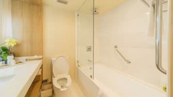 A modern bathroom with a toilet, sink, and glass-enclosed shower area.