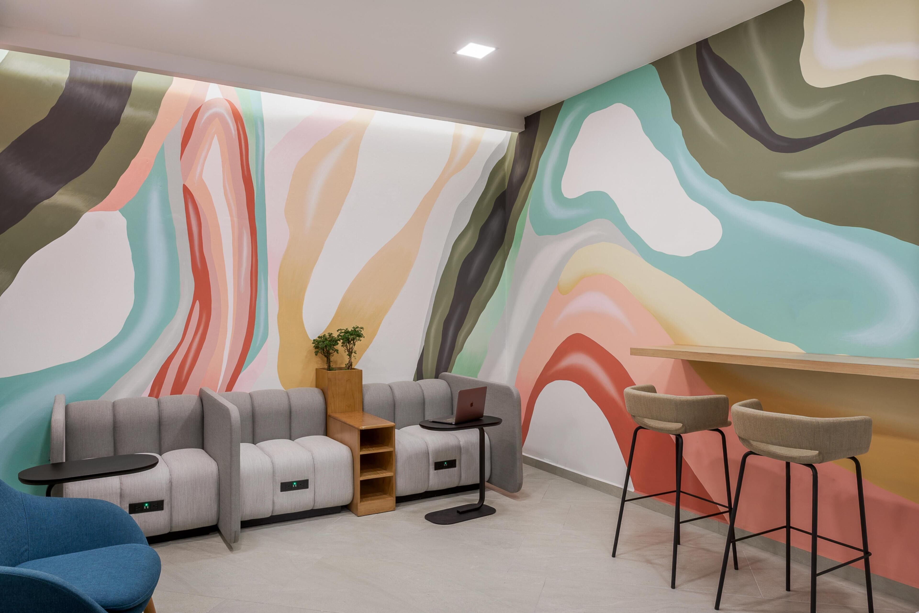 Een moderne zithoek met een bank, een klein tafeltje en barstoelen.