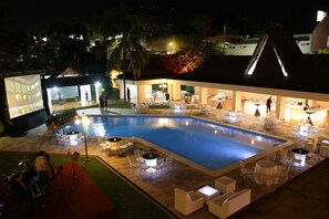 Una piscina al aire libre, sombrillas, sillones reclinables de piscina