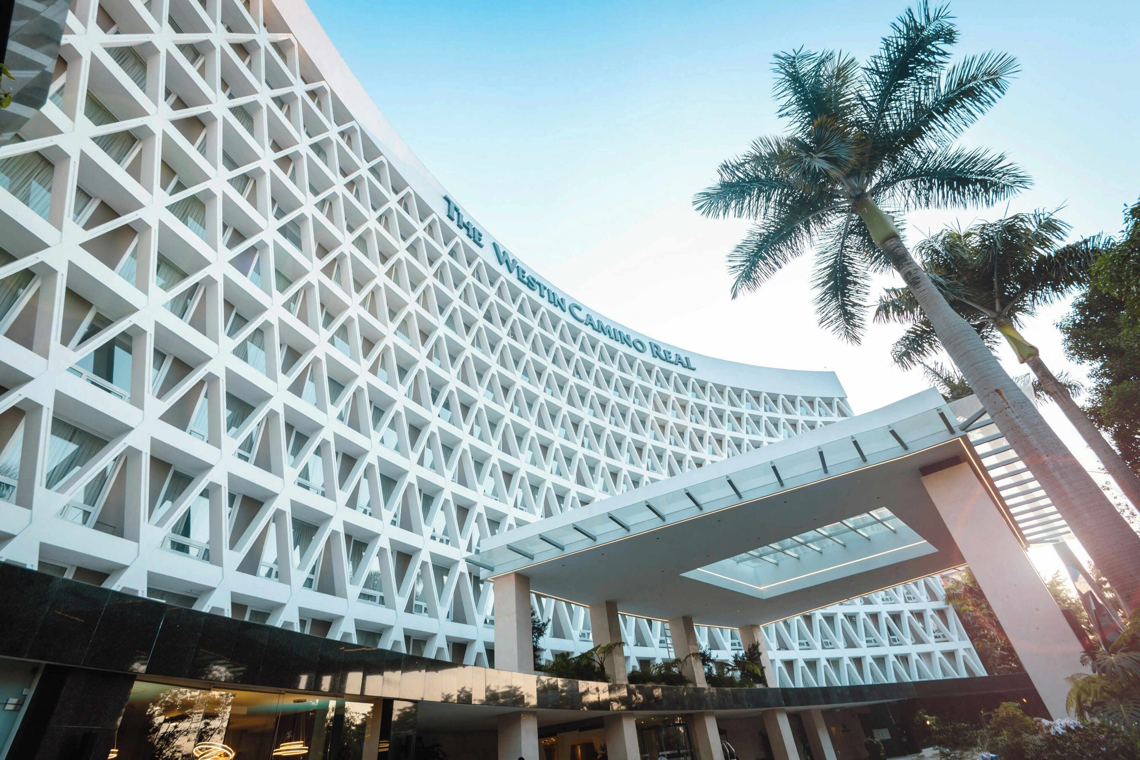 A modern hotel with a distinctive geometric facade and a covered walkway.