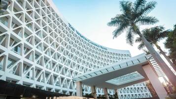 A modern hotel with a distinctive geometric facade and a covered walkway.