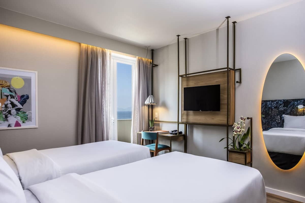 Habitación ejecutiva, 2 camas individuales, balcón, vista parcial al mar | Minibar, caja de seguridad en la habitación y escritorio