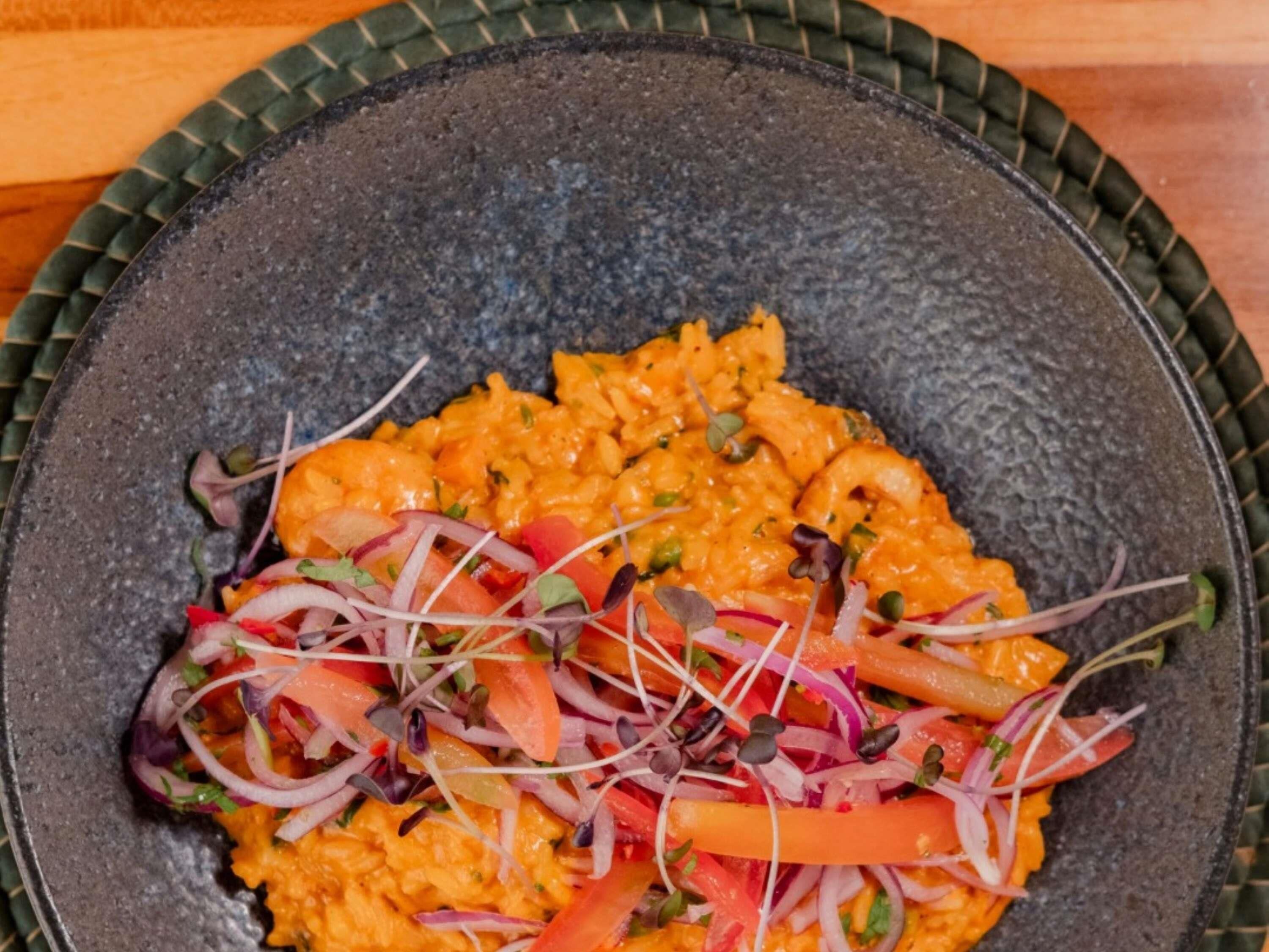 A bowl of food with a textured dark bowl.