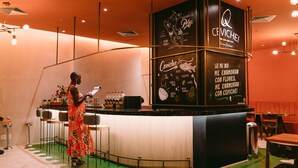 A bar area with a counter, stools, and a person standing by the counter. - Mercure Rio Boutique Hotel Copacabana (Rio de Janeiro)