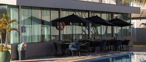 A DAN Inn Hotel with a swimming pool, outdoor seating, and palm trees.