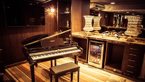 A grand piano, a bar area with a large mirror, and a minibar. - Hotel Dan Inn Uberaba & Convenções by Nacional Inn (Uberaba)