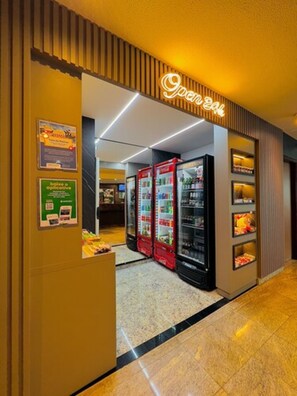 A hotel entrance with a neon sign reading "Open 24h". There are vending machines and a small display of snacks. - Hotel Dan Inn Uberaba & Convenções by Nacional Inn (Uberaba)