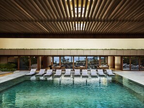 A modern indoor pool area with clear water, lounge chairs, and a view of the sea through large windows. - Fairmont Rio de Janeiro Copacabana (Rio de Janeiro)