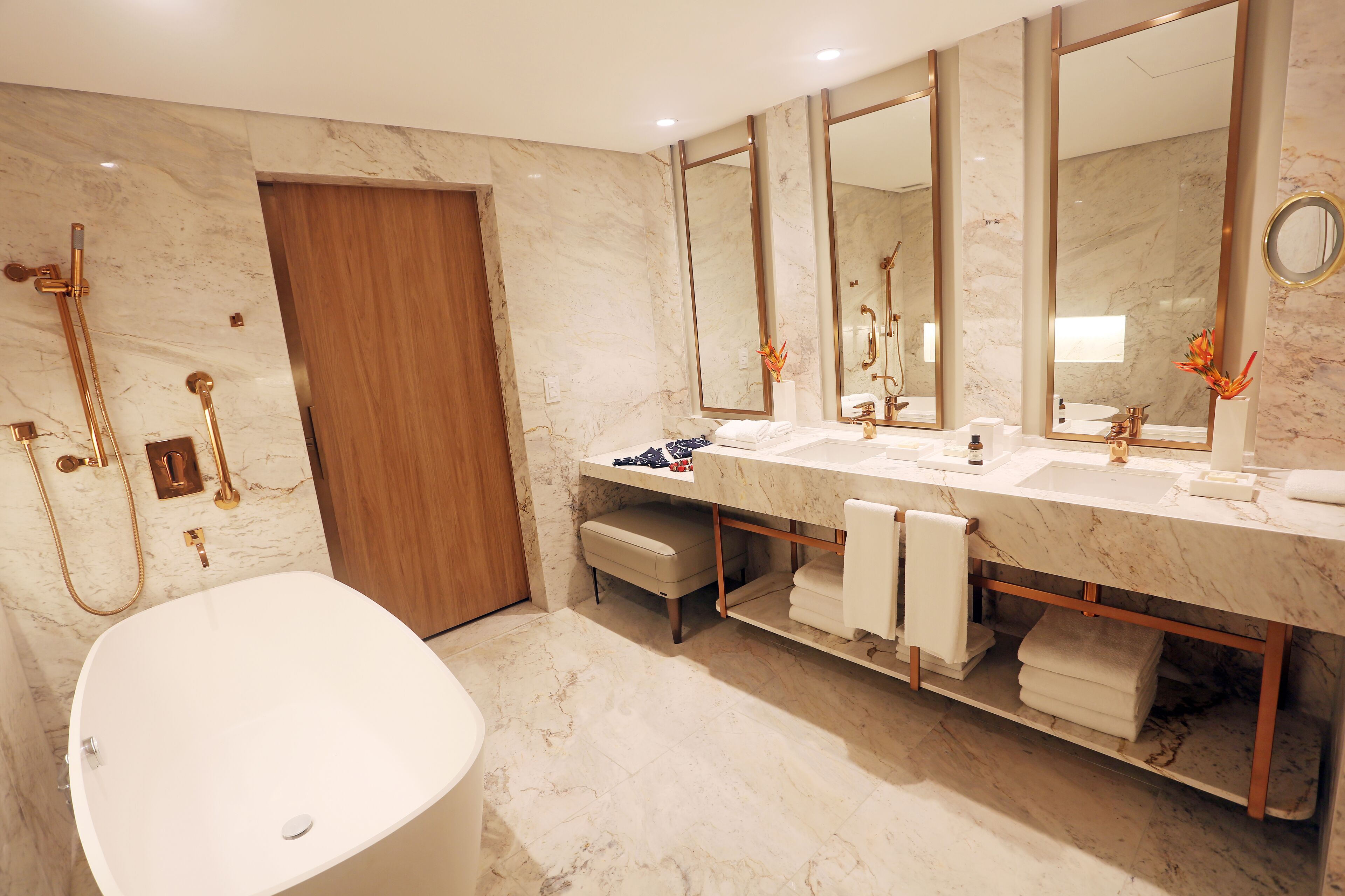 A modern bathroom with a freestanding bathtub, a double sink vanity, and a large mirror.