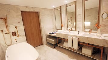 A modern bathroom with a freestanding bathtub, a double sink vanity, and a large mirror.
