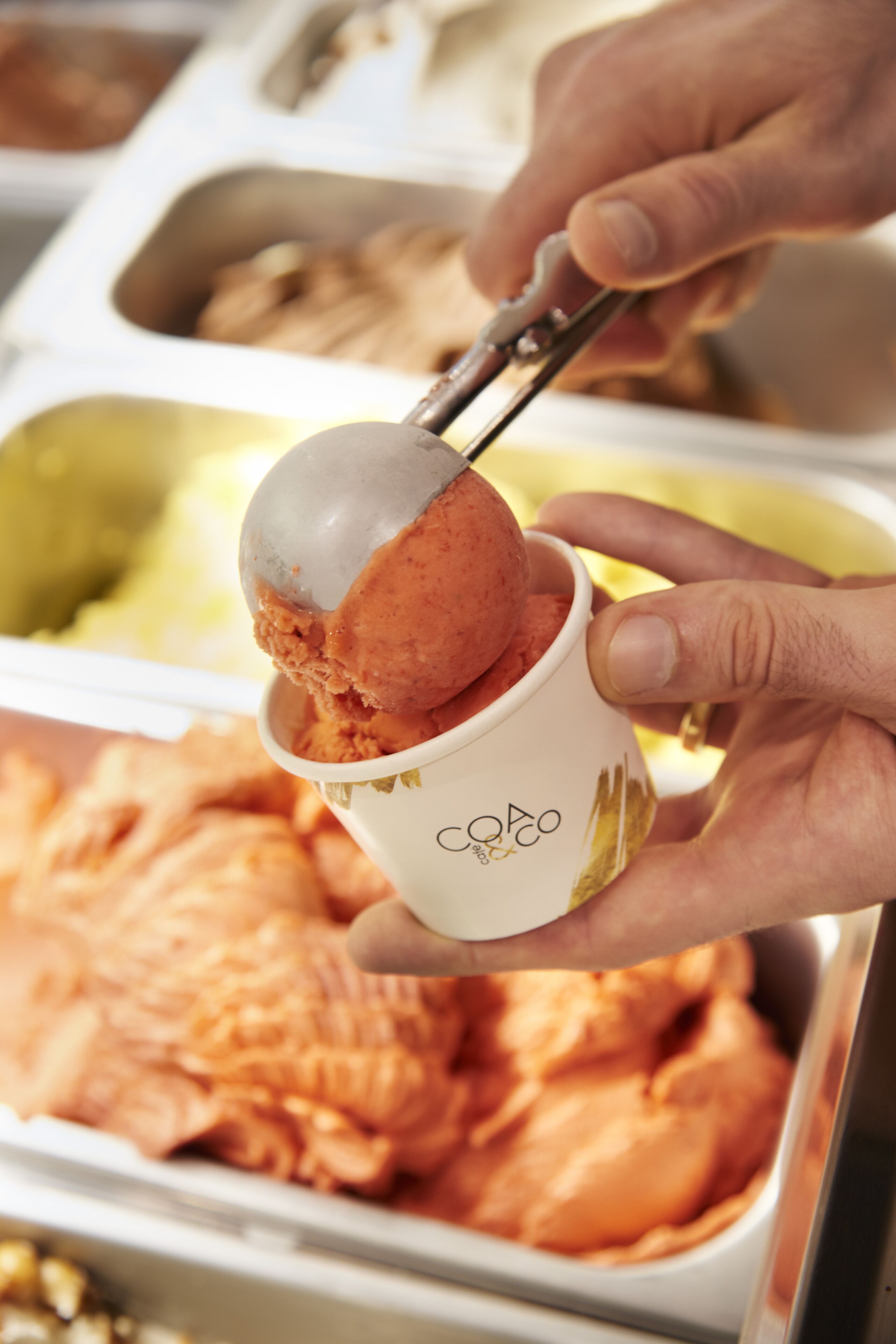 A person scooping ice cream from a cup.