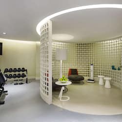 Exercise in comfort with a treadmill and dumbbells, plus a cozy reading nook.