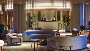 A modern hotel lobby with a reception desk, seating area, and large windows. - Fairmont Rio de Janeiro Copacabana (Rio de Janeiro)