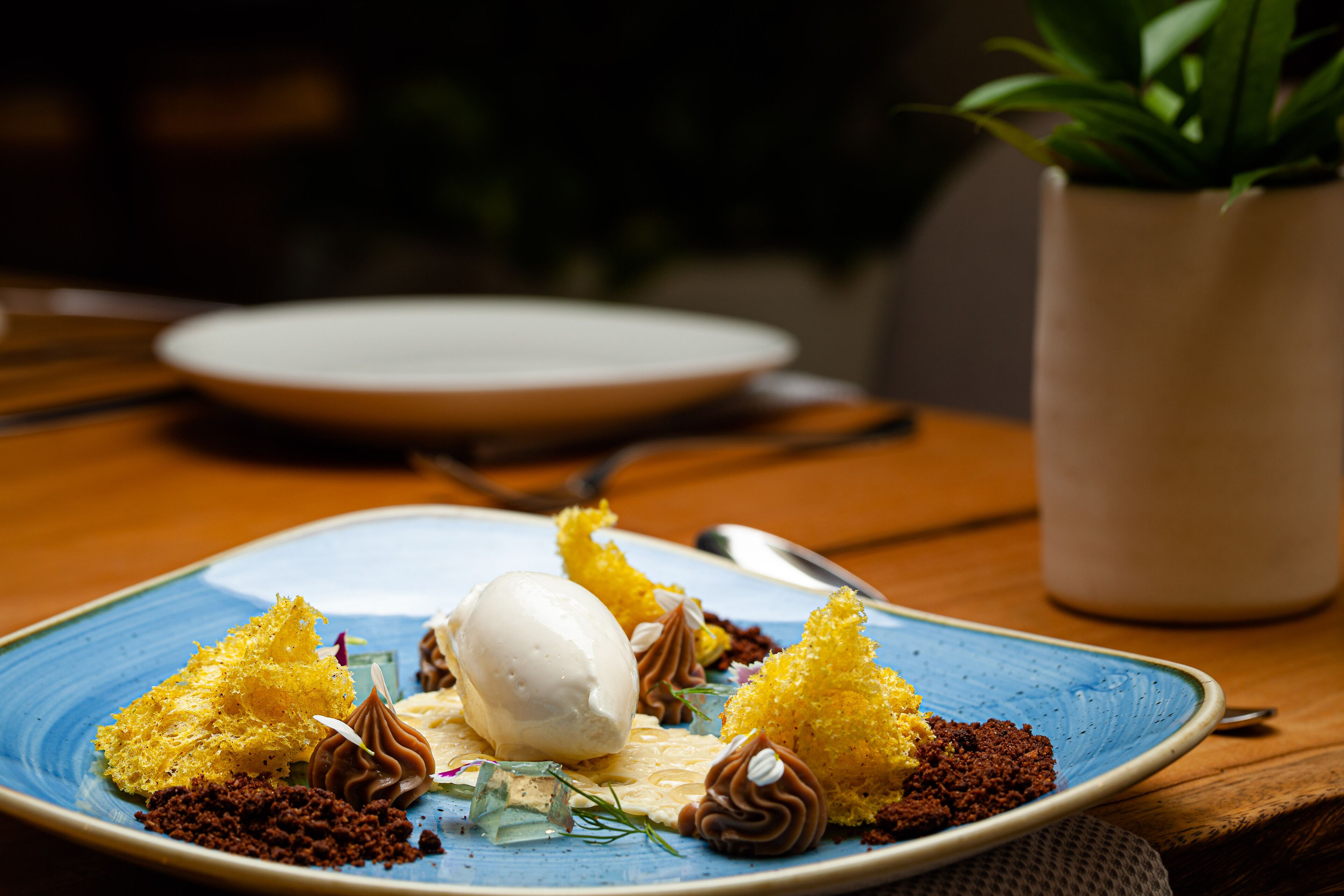 A dessert plate with various sweets and a scoop of ice cream on a blue plate.