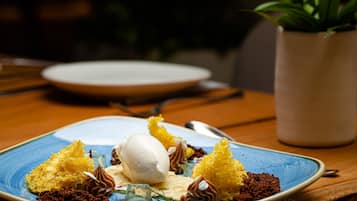 A dessert plate with various sweets and a scoop of ice cream on a blue plate.