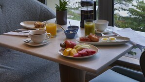 A breakfast table with a view of the sea, a hanging light fixture, and a potted plant. - Fairmont Rio de Janeiro Copacabana (Rio de Janeiro)