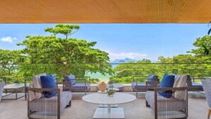 A terrace with outdoor seating, a table, and a view of the sea and mountains. - Fairmont Rio de Janeiro Copacabana (Rio de Janeiro)